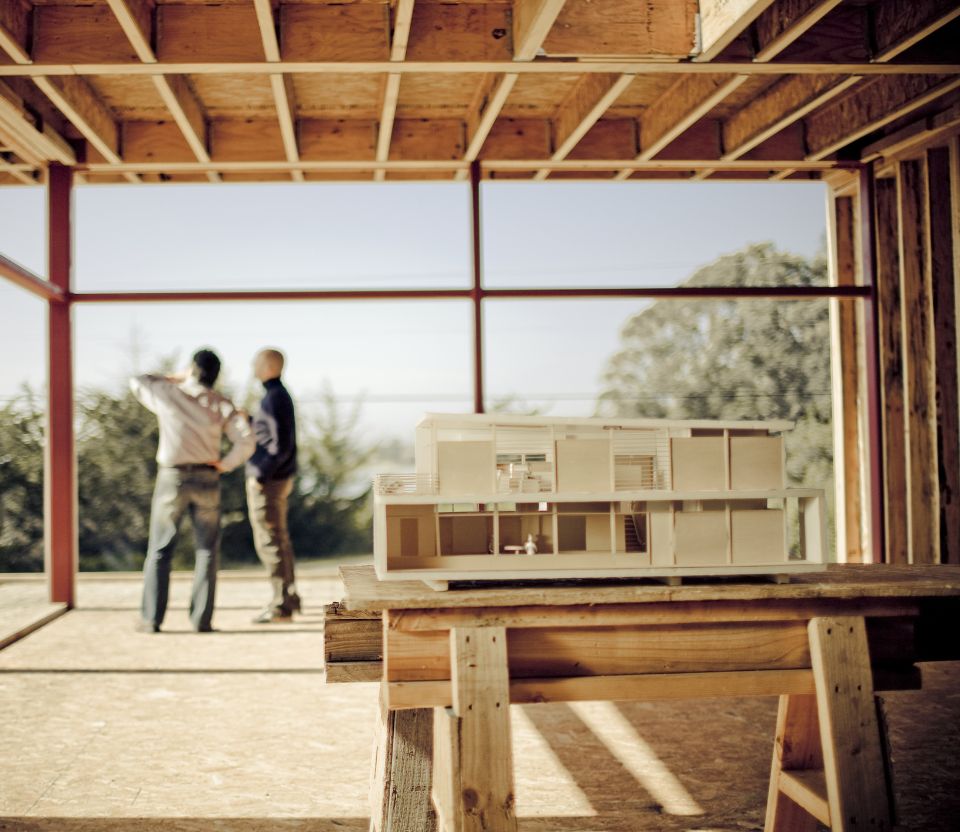 Dwie osoby rozmawiający ze sobą w miejscu budowy domu